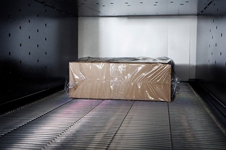 Package in a shrink tunnel being shrink wrapped