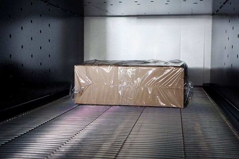 Package in a shrink tunnel being shrink wrapped