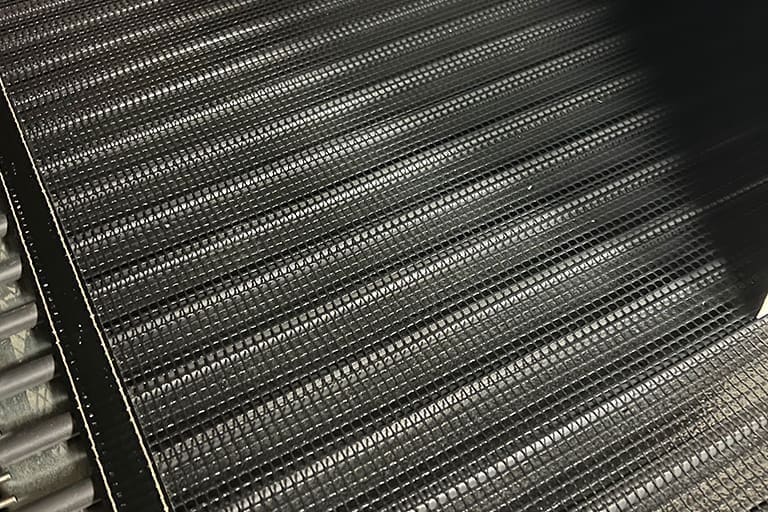 PTFE coated mesh belting overlay on a shrink tunnel