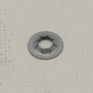 Metal washer on a textured surface.