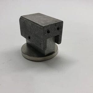 Metallic part on a round base.