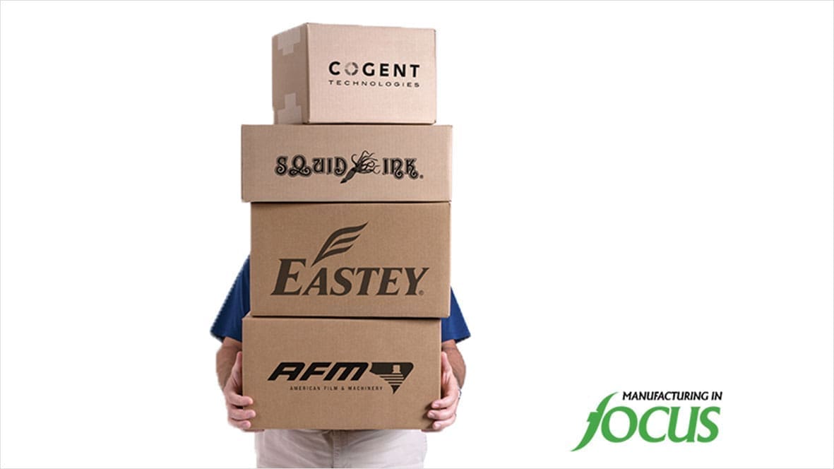Person holding four stacked cardboard boxes.